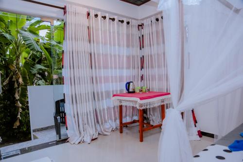 米瑞莎Sajana Ocean Hill的白色的客房设有桌子和窗户。
