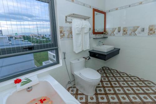 潘切Thọ Hướng Hotel - Phan Thiết的一间带卫生间、水槽和窗户的浴室