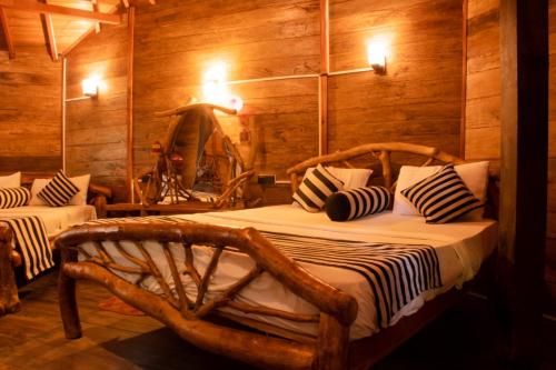 哈伯勒内Dudley Nature Resort的一间带两张床铺的卧室,位于带木墙的房间内