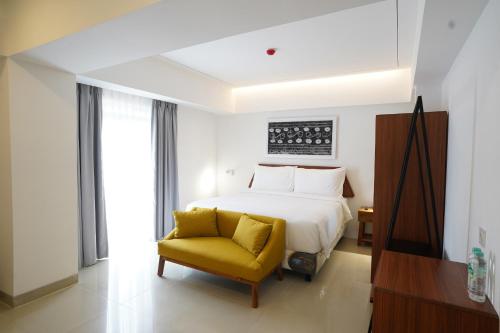 SigumparCoffee Hotel Ayola Dolok Sanggul的一间卧室配有一张床和一张黄色椅子