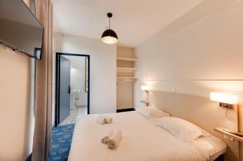 芒通圣贝尔纳花亭酒店的一间卧室配有带毛巾的床