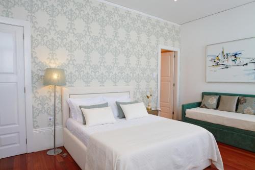 波尔图马尔克斯魅力旅馆的卧室配有白色的床和绿色沙发