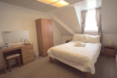 布莱克浦莫里西酒店的一间卧室配有一张床、一个梳妆台和一扇窗户。