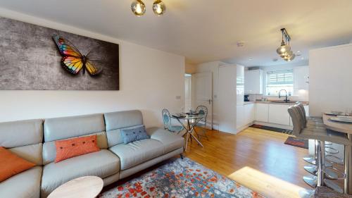 布罗姆利Sapphire Apartment Bromley Common的客厅配有沙发,墙上挂着蝴蝶画