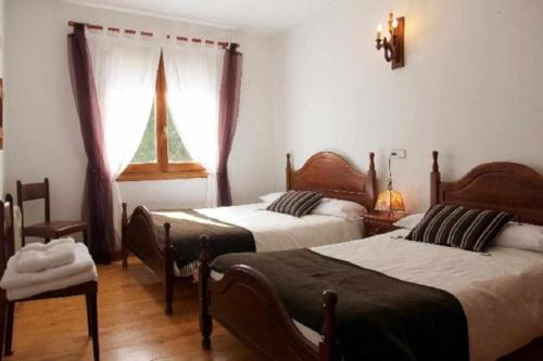 奥查加维亚Casa Rural Mantxoalorra的一间卧室设有两张床和窗户。