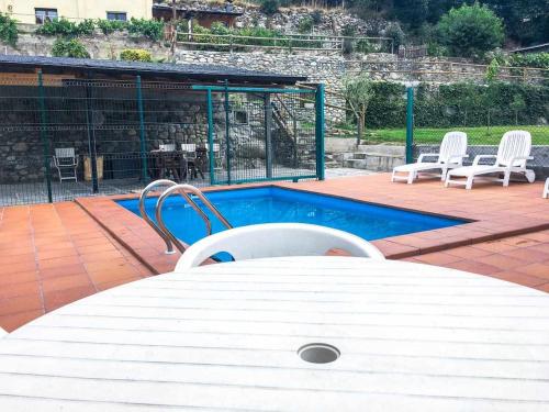 ArfaEl Jardí Casa rural ideal para familias y grupos的游泳池旁的白色桌椅