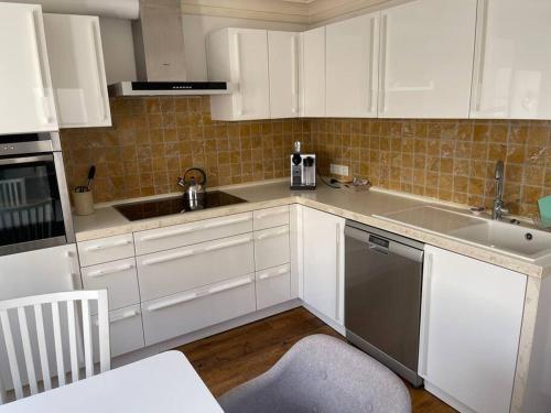 波恩Kleines, gemütliches Haus in Bonn的厨房配有白色橱柜、水槽和洗碗机。