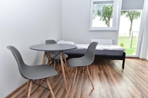 SmolecZielona Dolina 2020的一张桌子、四把椅子和一张位于房间里的床