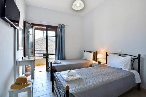 罗达Kerkyra Apartments的酒店客房设有两张床和窗户。
