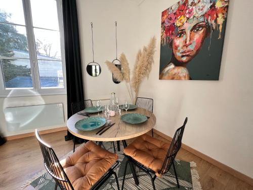 南特Le Belleville, proche hypercentre au calme, wifi的餐桌、椅子和墙上的绘画