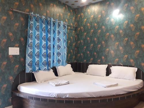 伯杰默里Hotel RAJVIHAR的壁纸覆盖的一张床位