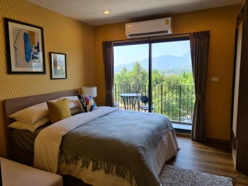 华欣Huahin mountain view room near the beach的一间卧室设有一张床和一个阳台的大窗户