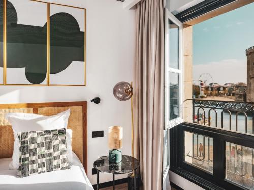 拉罗谢尔Maisons du Monde Hôtel & Suites - La Rochelle Vieux Port的客房设有一张床和一个阳台。