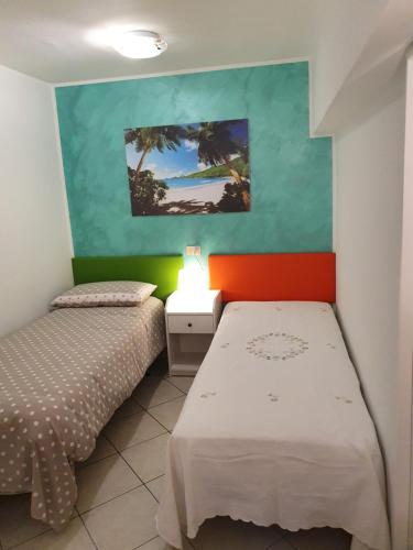 泰尔莫利Casa dell'ape Maia的一间卧室设有两张床,墙上挂着一幅画