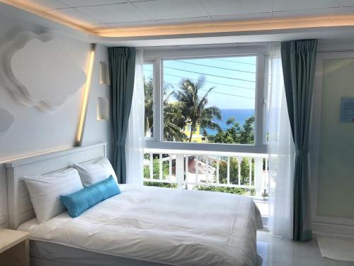 南湾 天空草的一间卧室设有一张床和一个大窗户