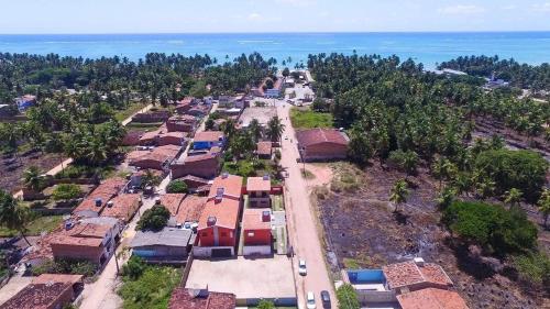 马拉戈日Casa Lua Cheia na Praia de Peroba, Maragogi的享有村庄和海洋的空中景致