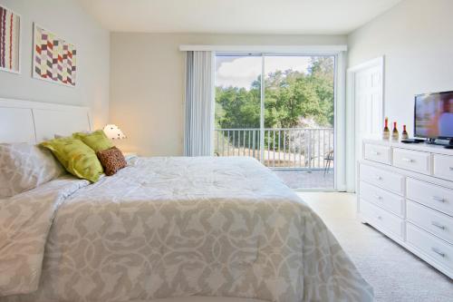 克莱蒙Serenity Resort 3 Bedroom Vacation Townhome with Pool (2008)的一间卧室配有一张床、一台电视和一个阳台
