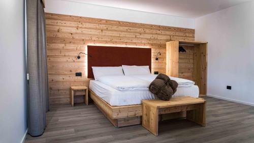 CampodennoALPS LOVER的卧室配有白色的床和木墙