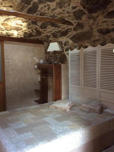 圣弗洛朗Bergerie tout confort L'immortelle的一间卧室设有一张床和石墙