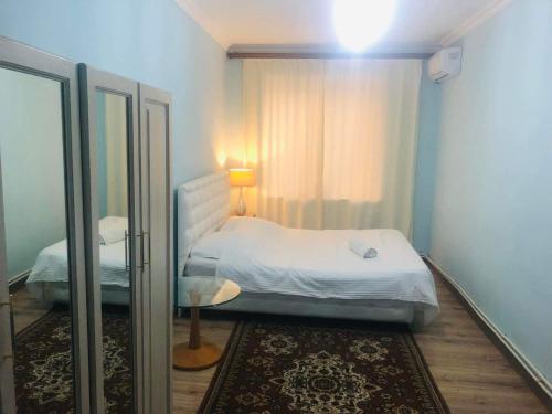 埃里温共和国广场公寓的一间小卧室,配有一张床和镜子