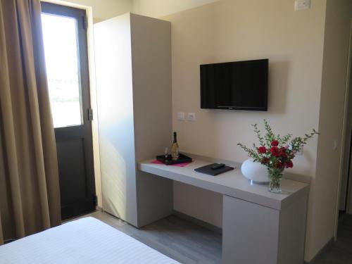 Vaiano Cremasco皮尤酒店及汽车旅馆的客房设有一张桌子,墙上配有电视。