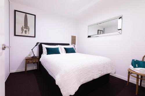 墨尔本Experience Port Melbourne的白色卧室配有床和镜子