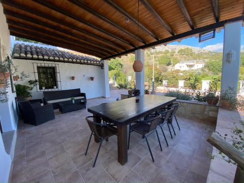 埃尔乔罗Casa Rural La teja (Caminito del Rey)的庭院配有木桌、椅子和沙发。