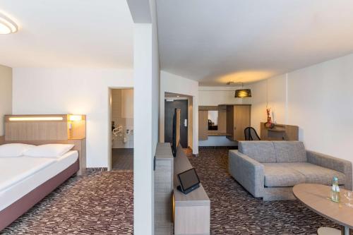 哥廷根哥廷根丽笙公园酒店的酒店客房,配有床和沙发