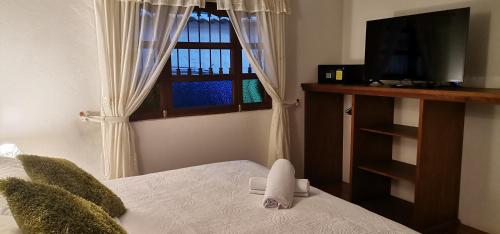莱瓦镇天使别墅酒店的一间卧室设有一张带窗户的床和一台电视。