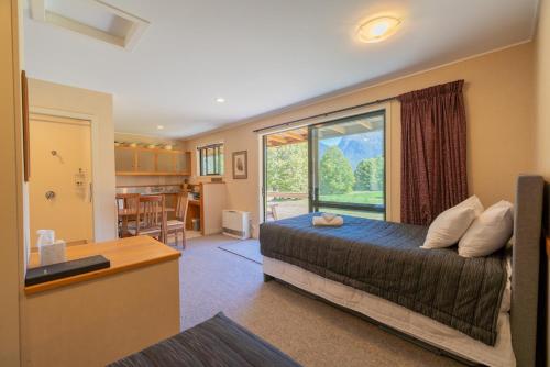 Te Anau DownsEglinton Valley Camp的一间卧室设有一张床和一个大窗户