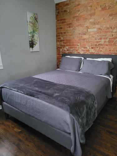 辛辛那提Modern style and comfort near UC的卧室内的一张床位,卧室设有砖墙