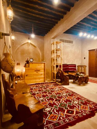 尼兹瓦Jawharat Alaqar Inn نزل جوهرة العقر的客厅的地板上铺有大地毯