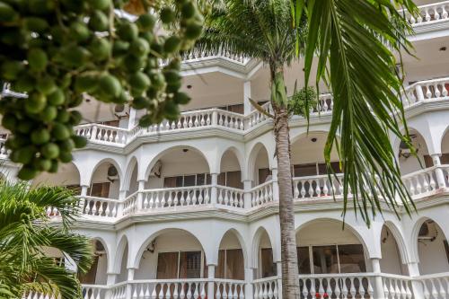 蒙巴萨城市蓝溪边酒店和套房的一座白色的建筑,前面有棕榈树