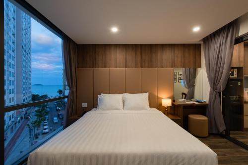 芽庄The Anchor Apartment - Nha Trang的一间卧室设有一张大床和一个大窗户