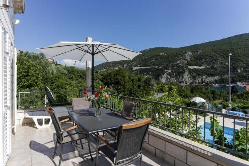 默克斯卡Villa Celenca的阳台配有桌椅和遮阳伞