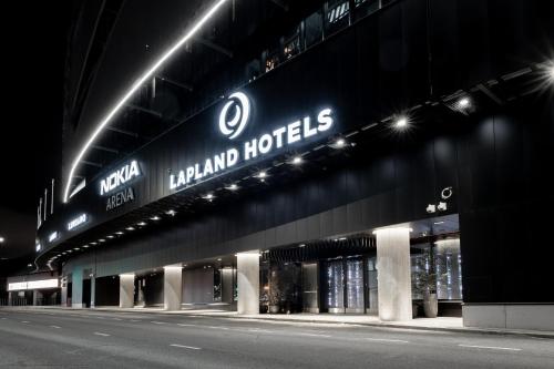 坦佩雷Lapland Hotels Arena的一座建筑物,晚上在建筑物的一侧有标志