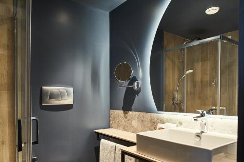 佩斯基耶拉博罗梅奥Belstay Milano Linate的一间带水槽和镜子的浴室