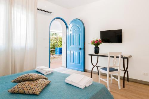 卡塔尼亚乐度纳西西里酒店的一间卧室设有蓝色的门、一张桌子和一张床