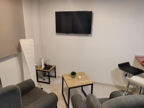 马德里Apartamento Madrid Norte的客厅配有沙发和墙上的电视