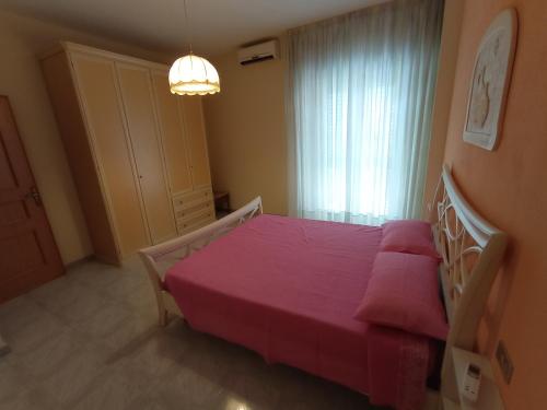 西尼斯科拉Carpe Diem的一间卧室设有红色的床和窗户。