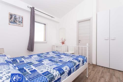 锡罗洛S210 - Sirolo, nuovissimo bilocale vista mare al primo piano的一间卧室配有一张带蓝色和白色被子的床