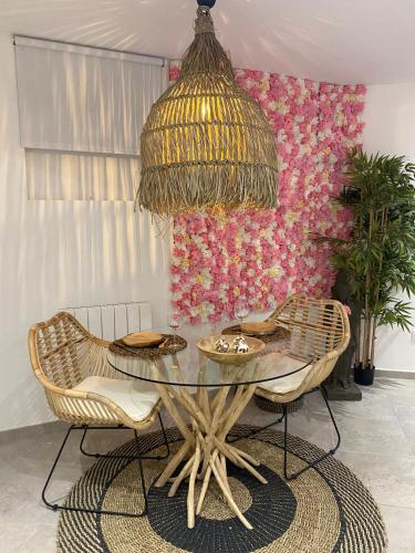 圣艾蒂安Studio cosy avec balnéothérapie的一间设有玻璃桌和椅子的用餐室