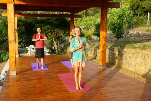 马尔恰纳Villa Shanti Yoga & Meditation的男人和女人在木甲板上做瑜伽