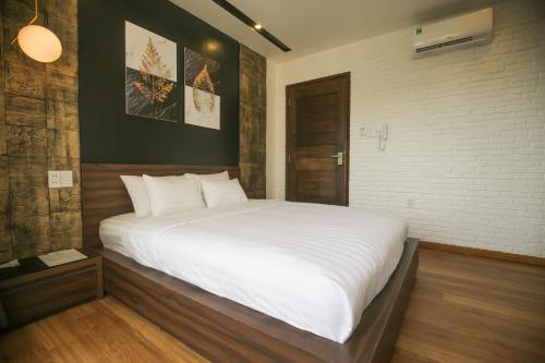 头顿Fati Boutique Hotel & Apartment的一间卧室配有一张带白色床单的大床
