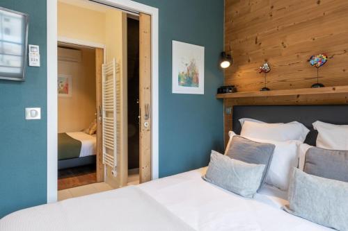 安锡ALPES Annecy Rent Lodge的卧室配有白色的床和木制床头板