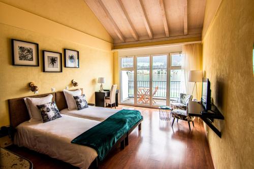 勒森蒂埃罗切利贝尔维酒店的一间卧室配有一张床和一台电视。