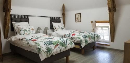 LarzacMoulin de l'Hoste的一间卧室设有两张床和窗户。