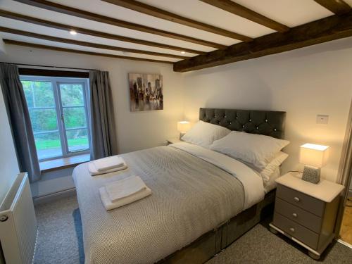 利德尼Swan House Tea Room and Bed & Breakfast的一间卧室设有一张大床和一个窗户。