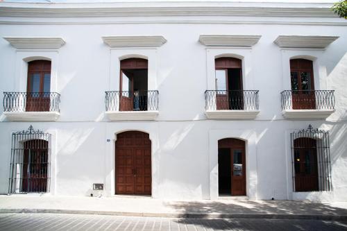 瓦哈卡市Pug Seal Oaxaca的白色的建筑,设有棕色的门窗