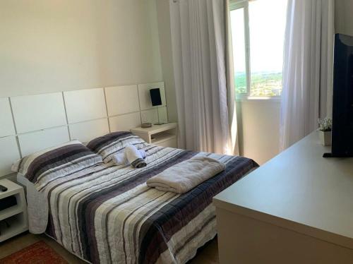 蓬塔格罗萨Sunset的卧室配有带枕头的床铺和窗户。
